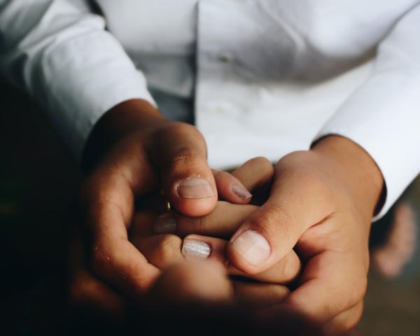 Photo of a set of hands holding another by Matheus Ferrero on Unsplash
