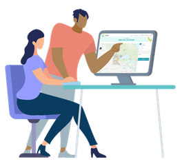 Two adults working at a computer, with one pointing to the screen