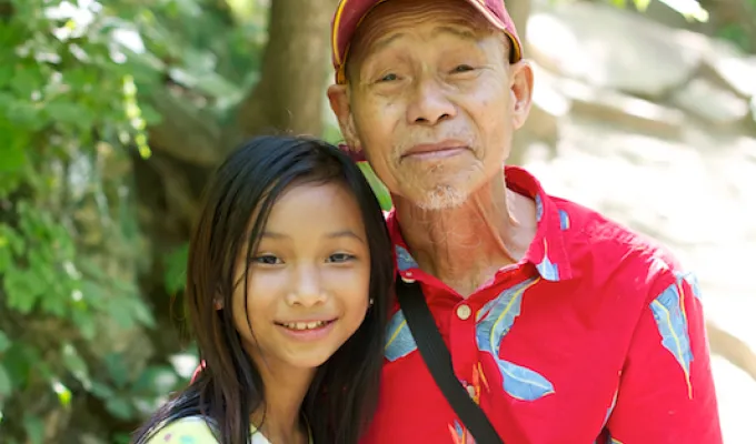 Photo of Asian older man and his pre-teen granddaughter.