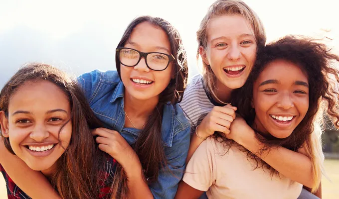Four teen girls about 14 years old smiling at the camera