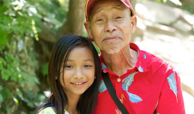 Photo of older Asian man and his pre-teen granddaughter