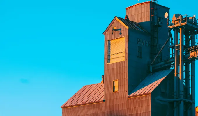 Photo of a grain elevator against a blue sky