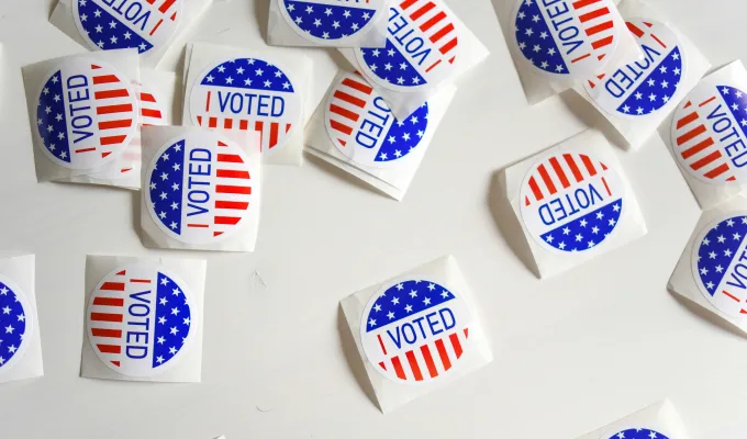 Photo of "I Voted" stickers, scattered on a white table top