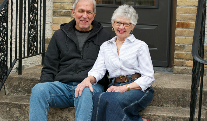 Older couple sitting on a front doorstep