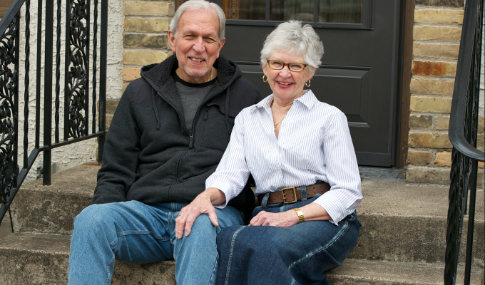 Photo of older couple sitting on front step
