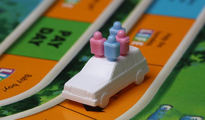 Close-up of Life game, showing a car token with four pegs
