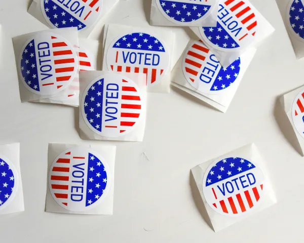 Photo of "I Voted" stickers scattered on a white surface