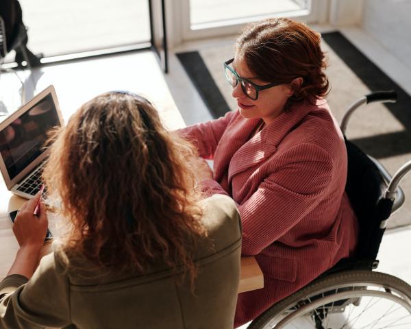 Photo of woman in wheelchair in an office meeting by Marcus Aurelius from Pexels