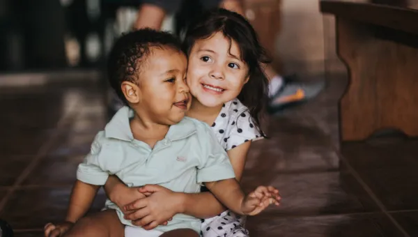 Young girl hugging baby