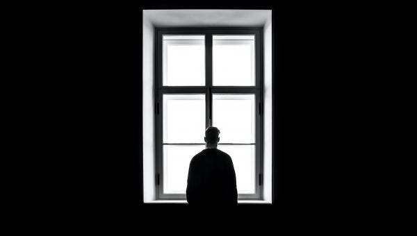man looking out a window