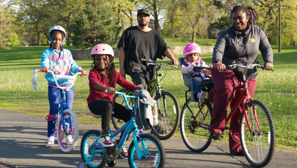 Photo of an African American family on bicycles.