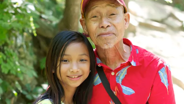 Photo of Asian older man and his pre-teen granddaughter.